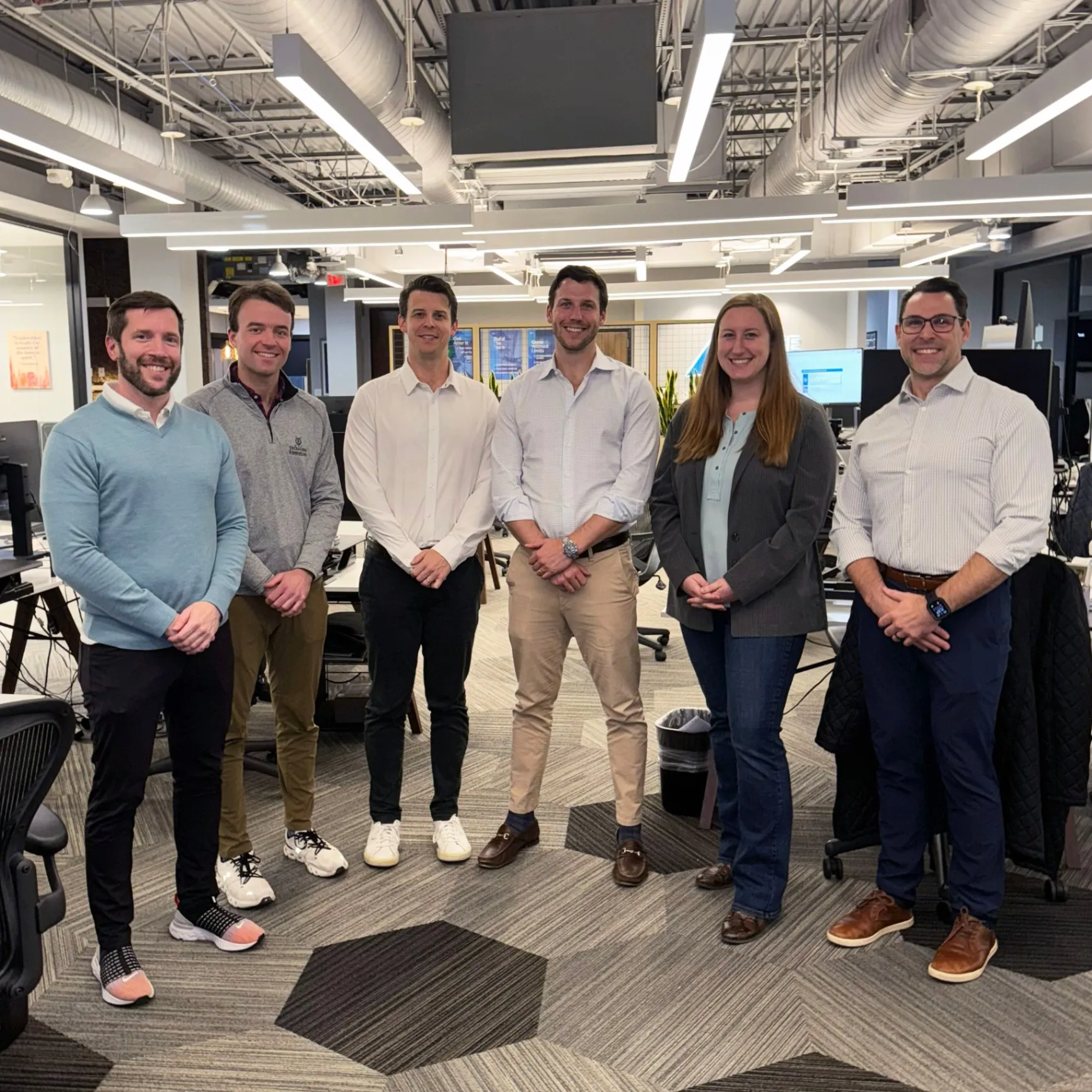 Team members standing together in modern office space