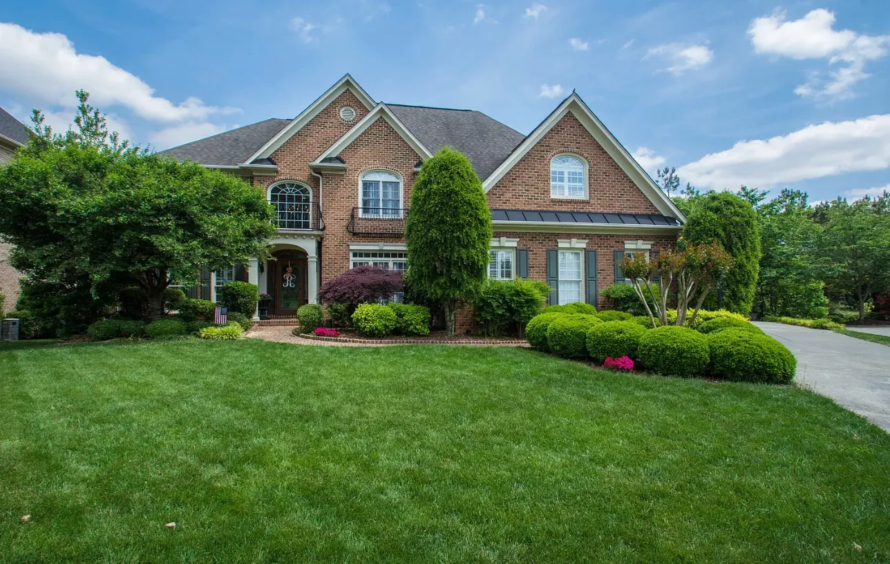 Large brick traditional home with mature landscaping